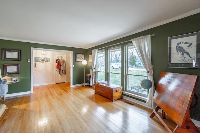 living area featuring crown molding and light hardwood / wood-style floors