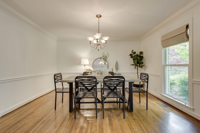 dining room featuring a notable chandelier, wood-type flooring, plenty of natural light, and crown molding