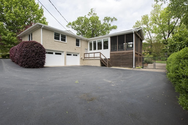 view of front of property featuring a garage and a sunroom