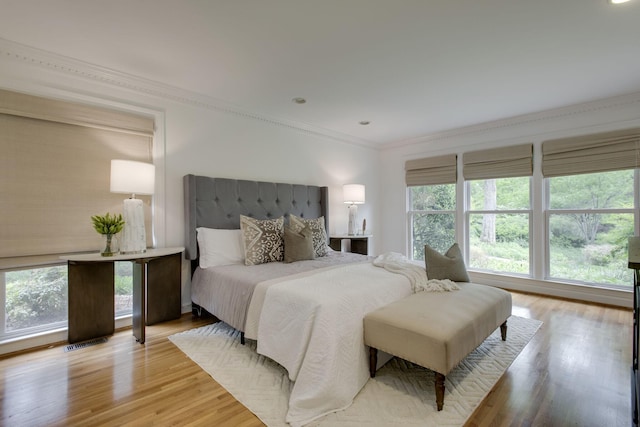 bedroom with crown molding and light hardwood / wood-style floors