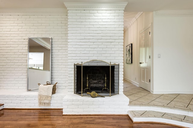 interior details with wood-type flooring, crown molding, and a brick fireplace