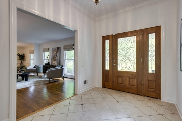 entryway featuring light tile patterned floors and ornamental molding