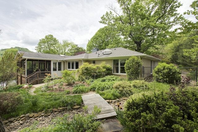 rear view of house featuring a sunroom