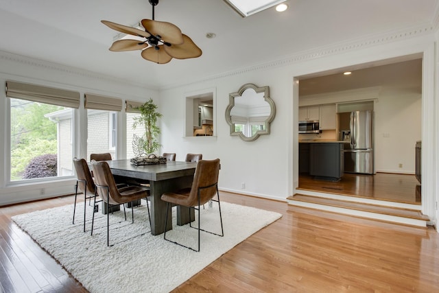 dining space with light wood-type flooring, ceiling fan, and crown molding