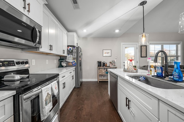 kitchen featuring light stone countertops, appliances with stainless steel finishes, sink, dark hardwood / wood-style floors, and white cabinetry