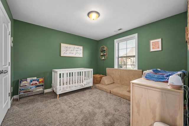 carpeted bedroom featuring a nursery area