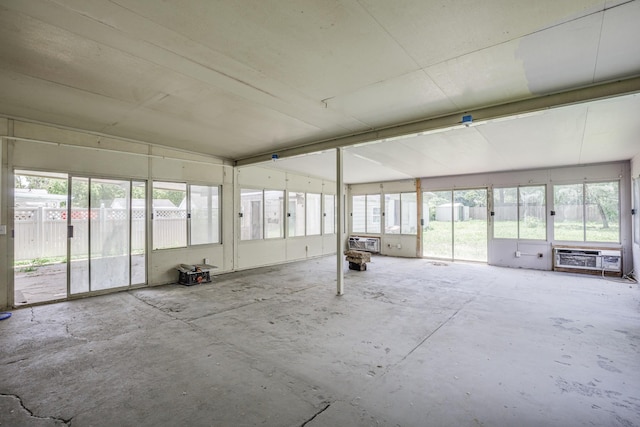 unfurnished sunroom with a wall mounted AC