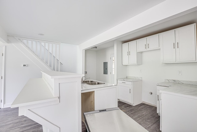 kitchen with white cabinets, electric panel, a kitchen island, and sink