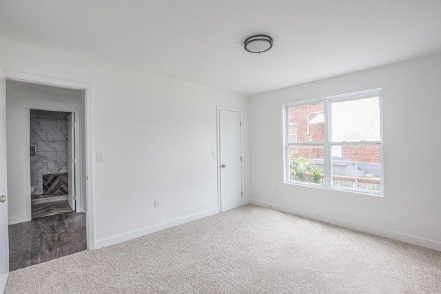 unfurnished room with dark colored carpet