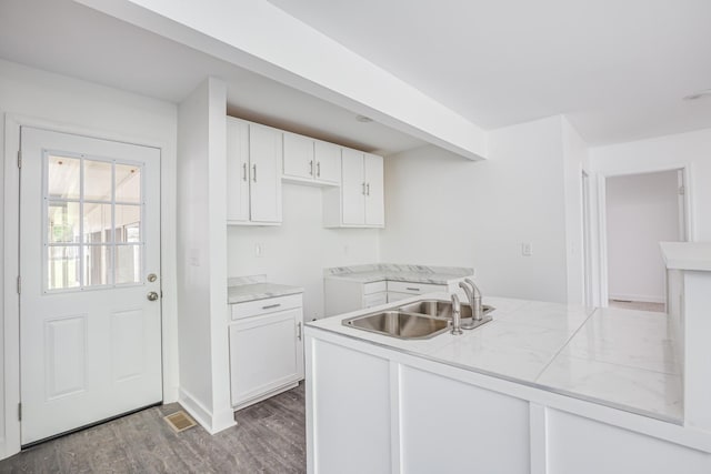 kitchen featuring beam ceiling, dark hardwood / wood-style flooring, sink, and white cabinets