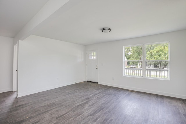 interior space featuring beamed ceiling and dark hardwood / wood-style floors