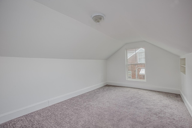 bonus room with carpet and vaulted ceiling