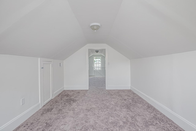 bonus room featuring light colored carpet and vaulted ceiling