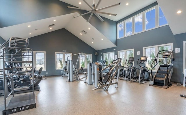 exercise room with ceiling fan and a high ceiling