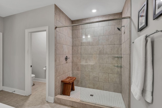 bathroom with tiled shower, tile patterned floors, and toilet