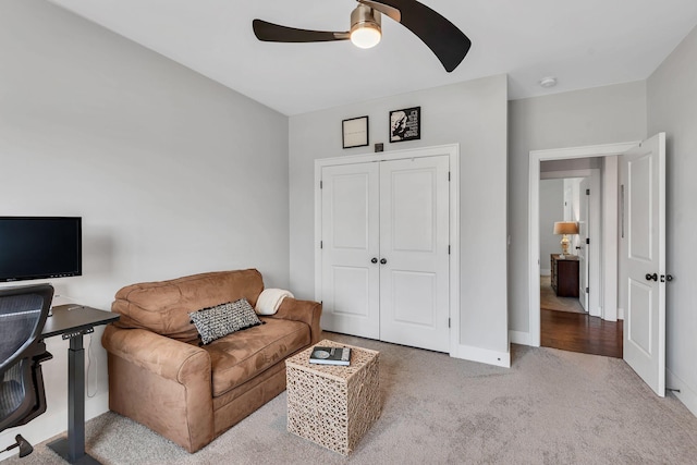 carpeted living room featuring ceiling fan