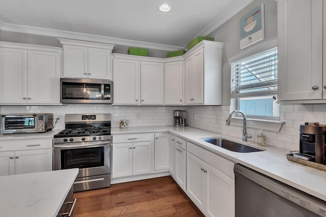 kitchen with decorative backsplash, sink, white cabinets, and stainless steel appliances