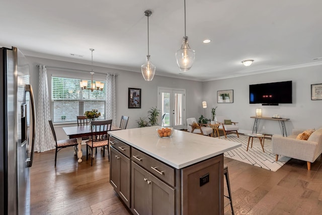 kitchen featuring a center island, hanging light fixtures, dark hardwood / wood-style flooring, stainless steel refrigerator with ice dispenser, and crown molding