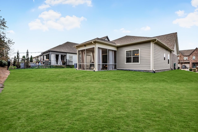 rear view of property with a sunroom and a yard