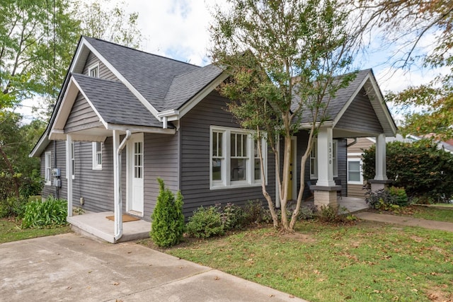 view of front of home with a porch and a front lawn