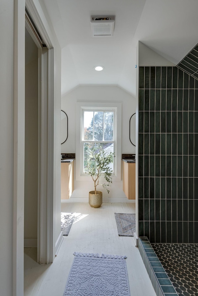 bathroom featuring a shower and vaulted ceiling