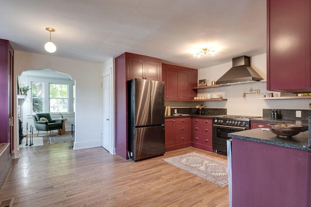 kitchen with wall chimney exhaust hood, stainless steel appliances, and light wood-type flooring