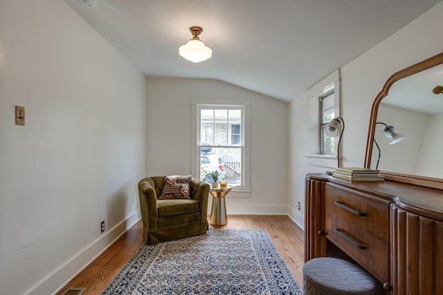 living area with light hardwood / wood-style floors and vaulted ceiling