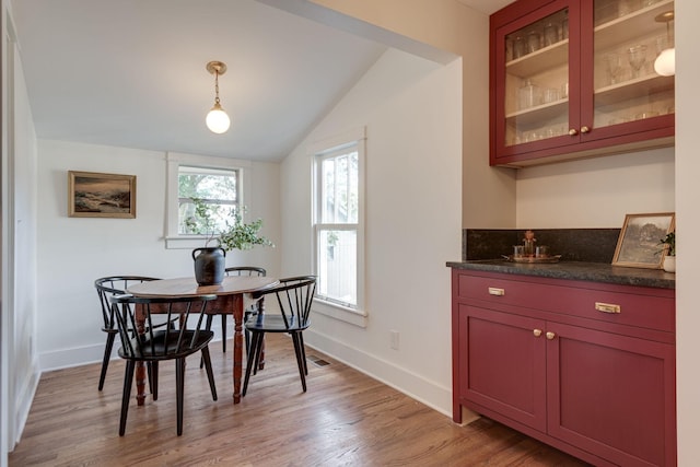 dining space featuring light hardwood / wood-style floors and vaulted ceiling