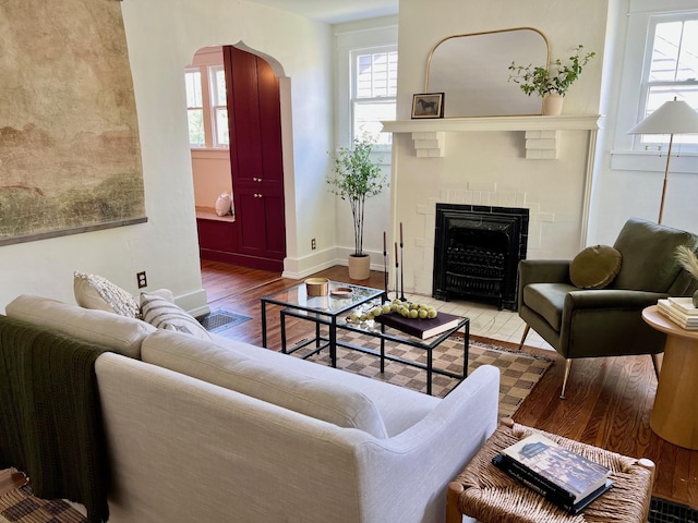 living room with hardwood / wood-style floors and a brick fireplace