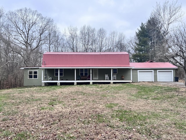 view of front facade featuring covered porch, a front yard, and a garage