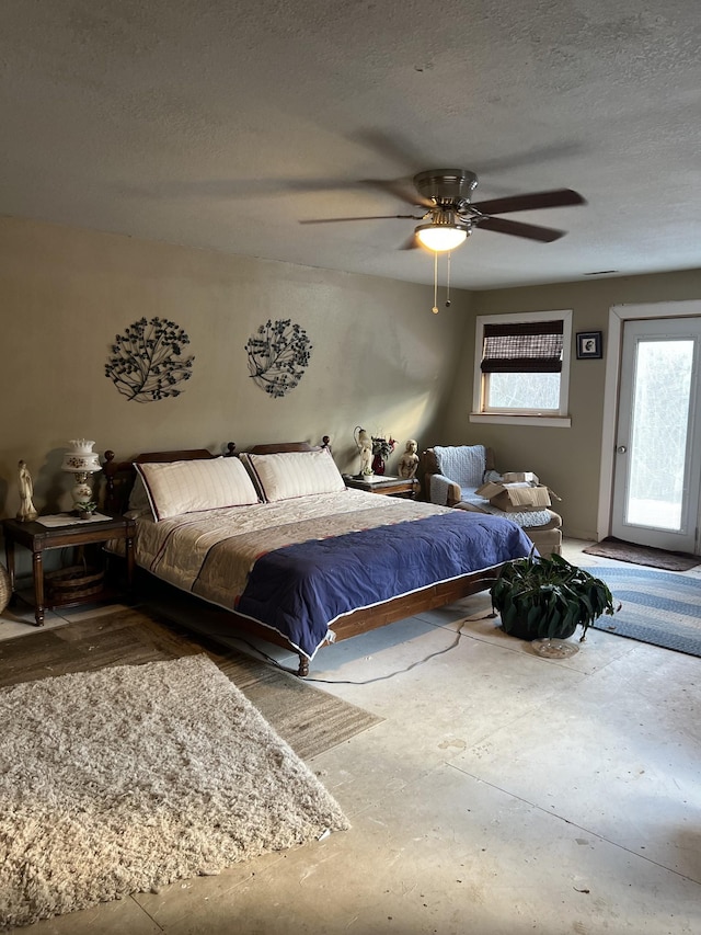 bedroom with ceiling fan and a textured ceiling