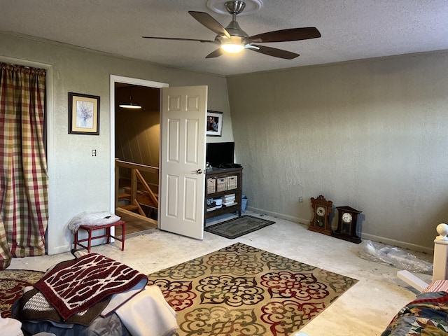 living room featuring ceiling fan and a textured ceiling