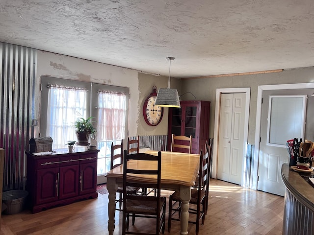 dining area with wood-type flooring and a textured ceiling