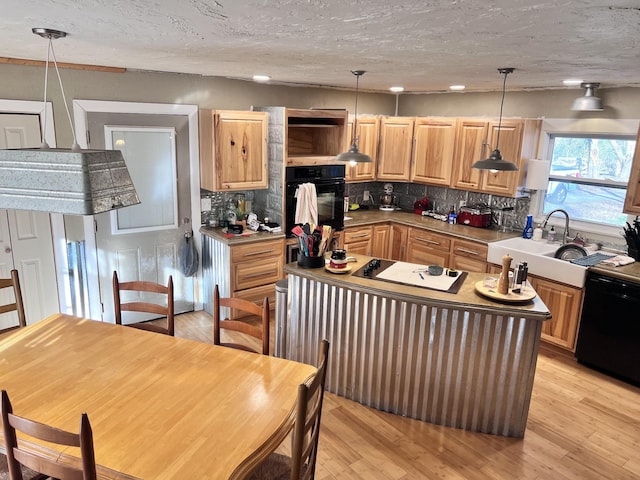 kitchen with sink, pendant lighting, a textured ceiling, decorative backsplash, and black appliances