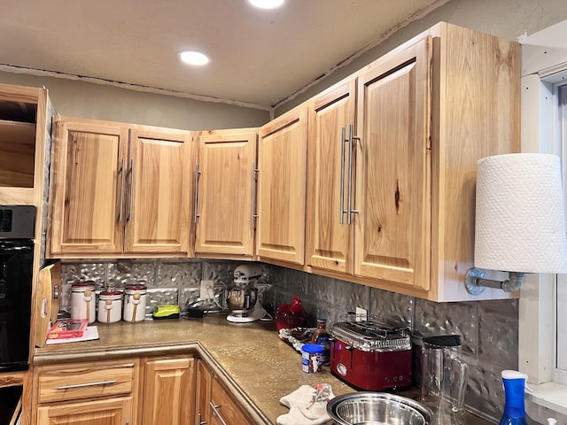 kitchen with tasteful backsplash and black oven