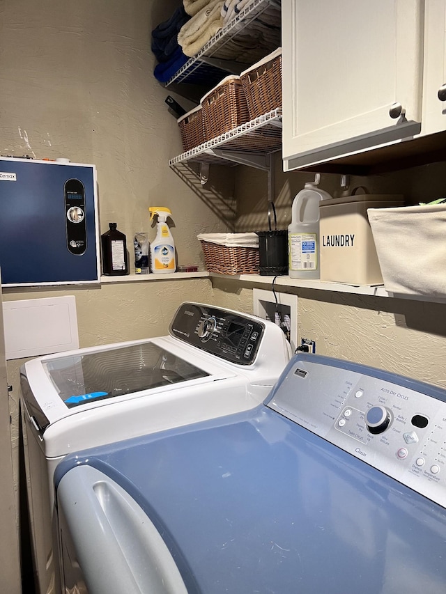 washroom with washer and clothes dryer and cabinets