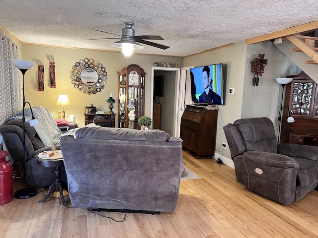 living room featuring a textured ceiling, light hardwood / wood-style floors, and ceiling fan