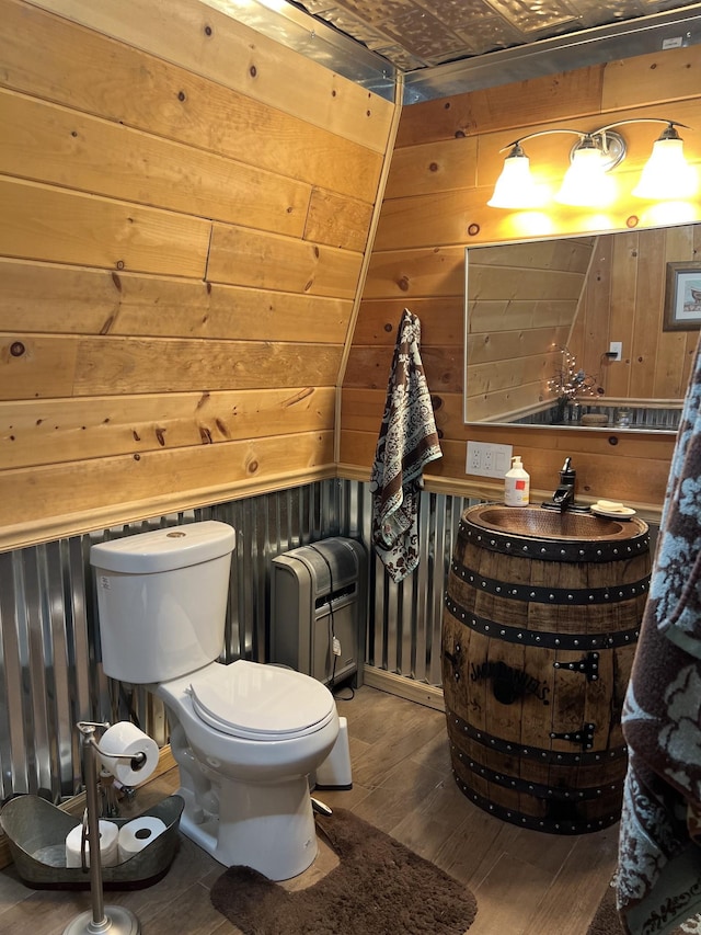 bathroom featuring lofted ceiling, wood walls, toilet, and wood-type flooring