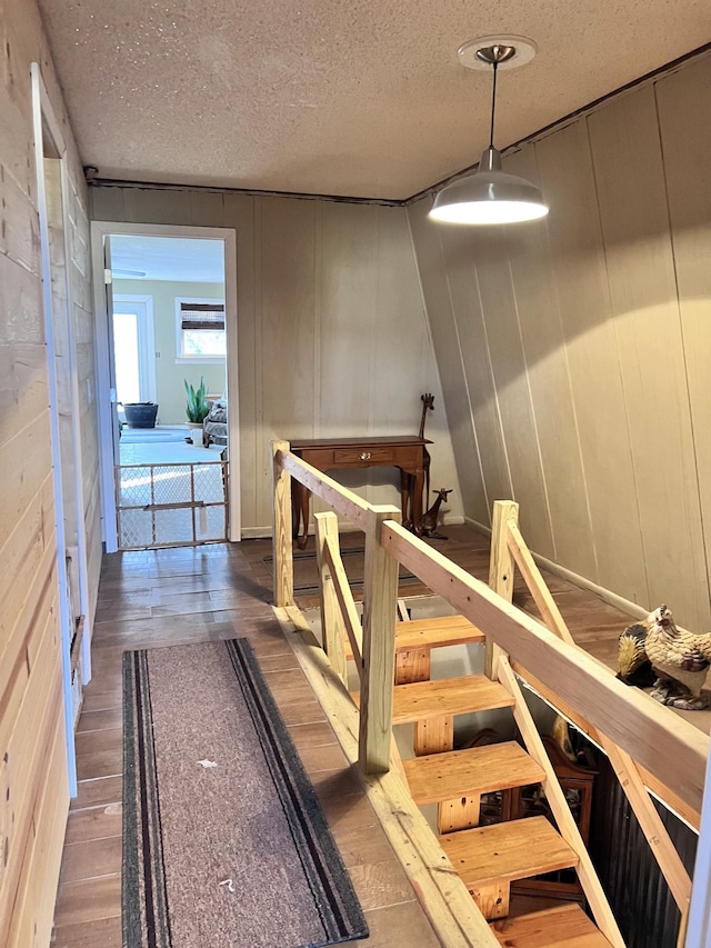 hallway with hardwood / wood-style floors and a textured ceiling