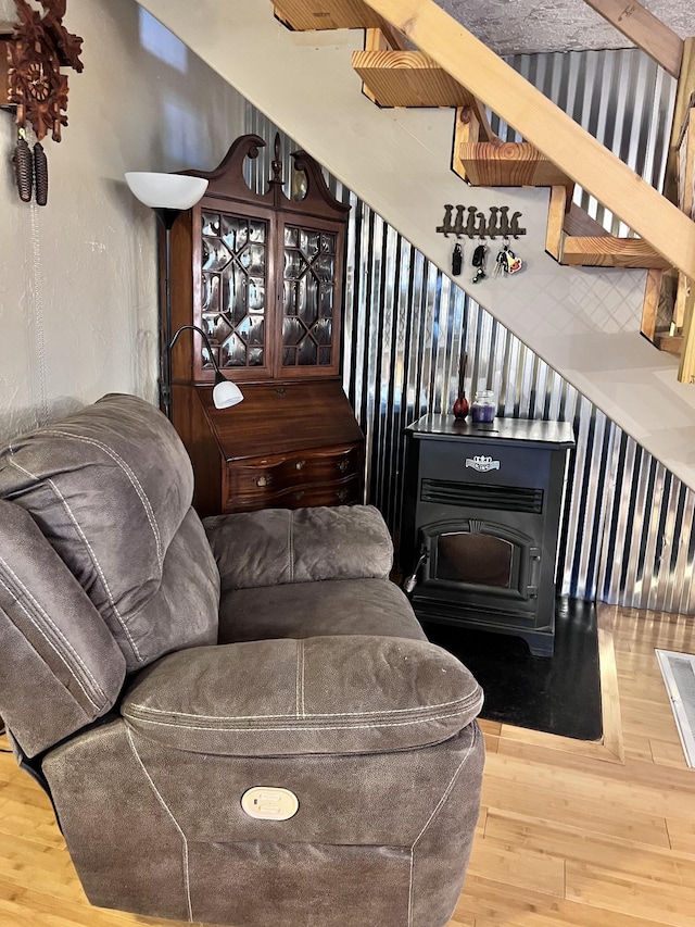 living room with a wood stove and hardwood / wood-style flooring