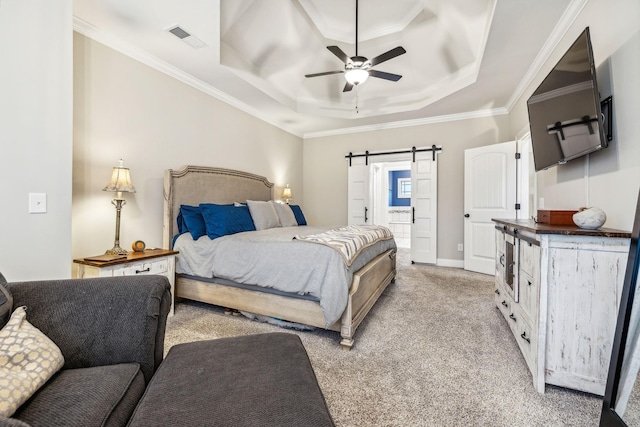 carpeted bedroom with a barn door, a tray ceiling, ceiling fan, and ornamental molding