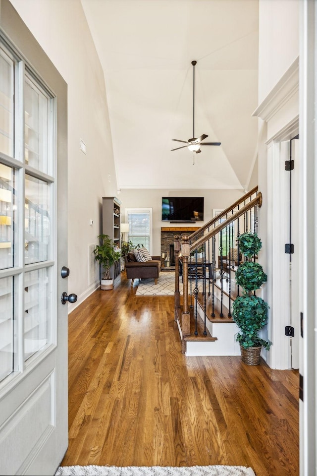 entrance foyer featuring a wealth of natural light, a fireplace, lofted ceiling, and hardwood / wood-style flooring