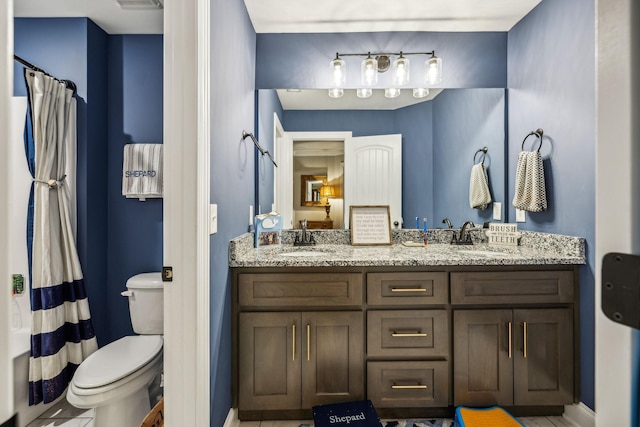 bathroom with tile patterned flooring, vanity, and toilet