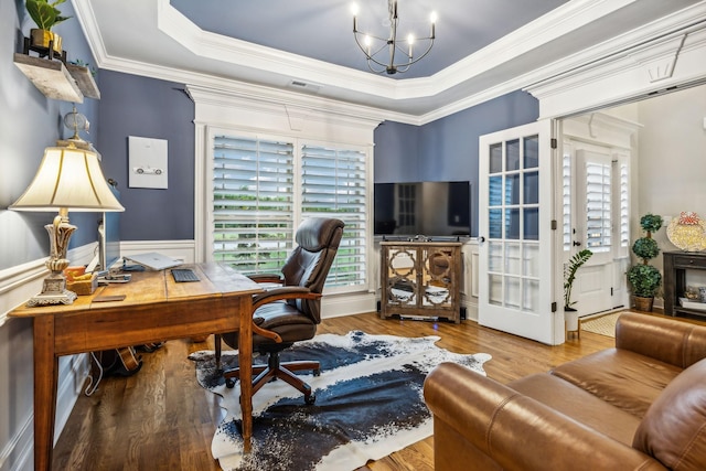 office area featuring a tray ceiling, crown molding, a chandelier, and wood-type flooring