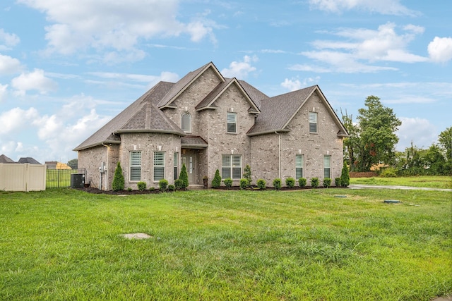 french country inspired facade featuring a front yard and central AC