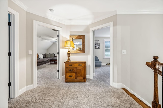 hallway with carpet, ornamental molding, and lofted ceiling