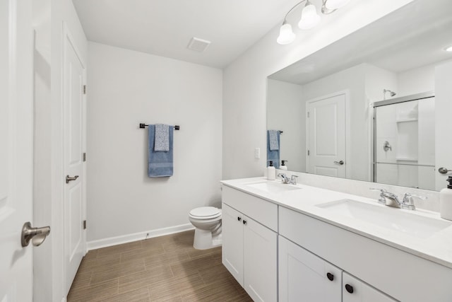 bathroom with vanity, toilet, and a shower with shower door