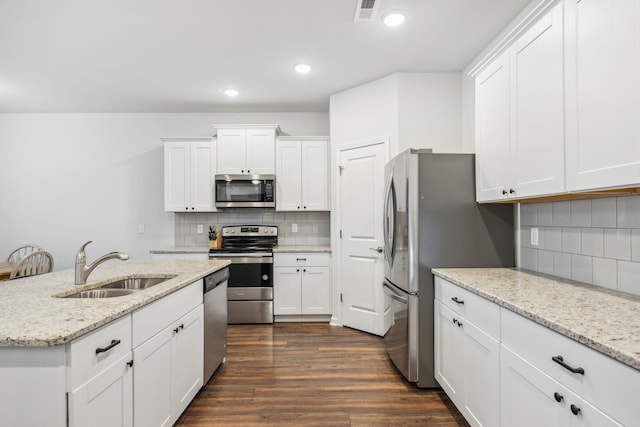 kitchen with backsplash, white cabinetry, sink, and stainless steel appliances