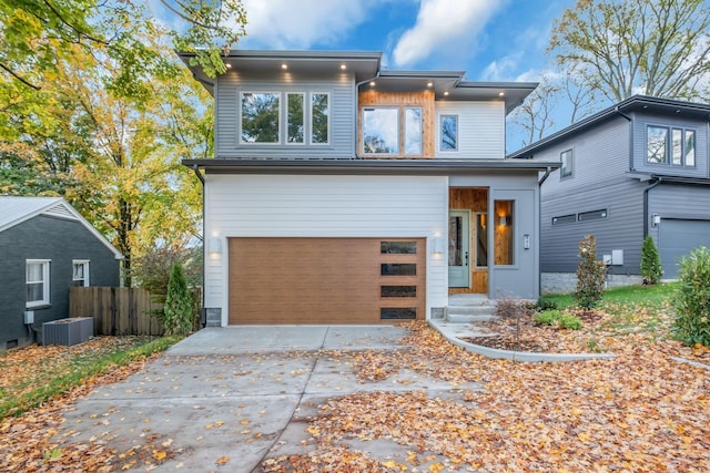 contemporary house featuring central AC unit and a garage