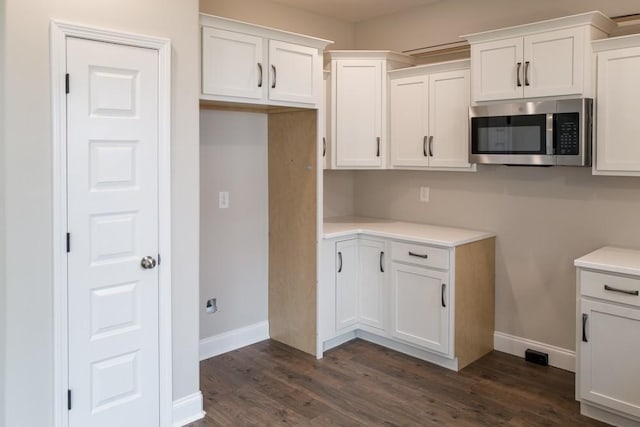 kitchen with dark hardwood / wood-style flooring and white cabinetry